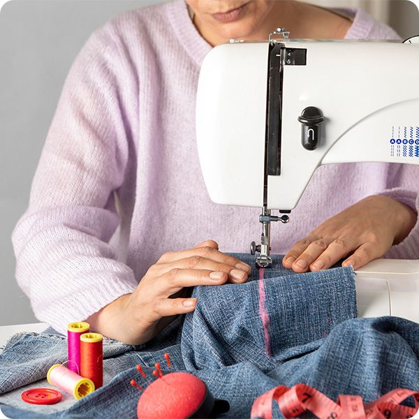 person sewing with a sewing machine