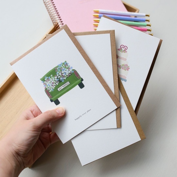 Conjuntos de postales de Kartotek, donde la primera es con un coche verde y el texto "Felices para siempre".